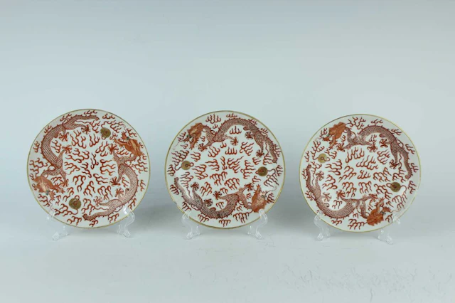 Lot 113 - Three Chinese iron-red 'dragons chasing