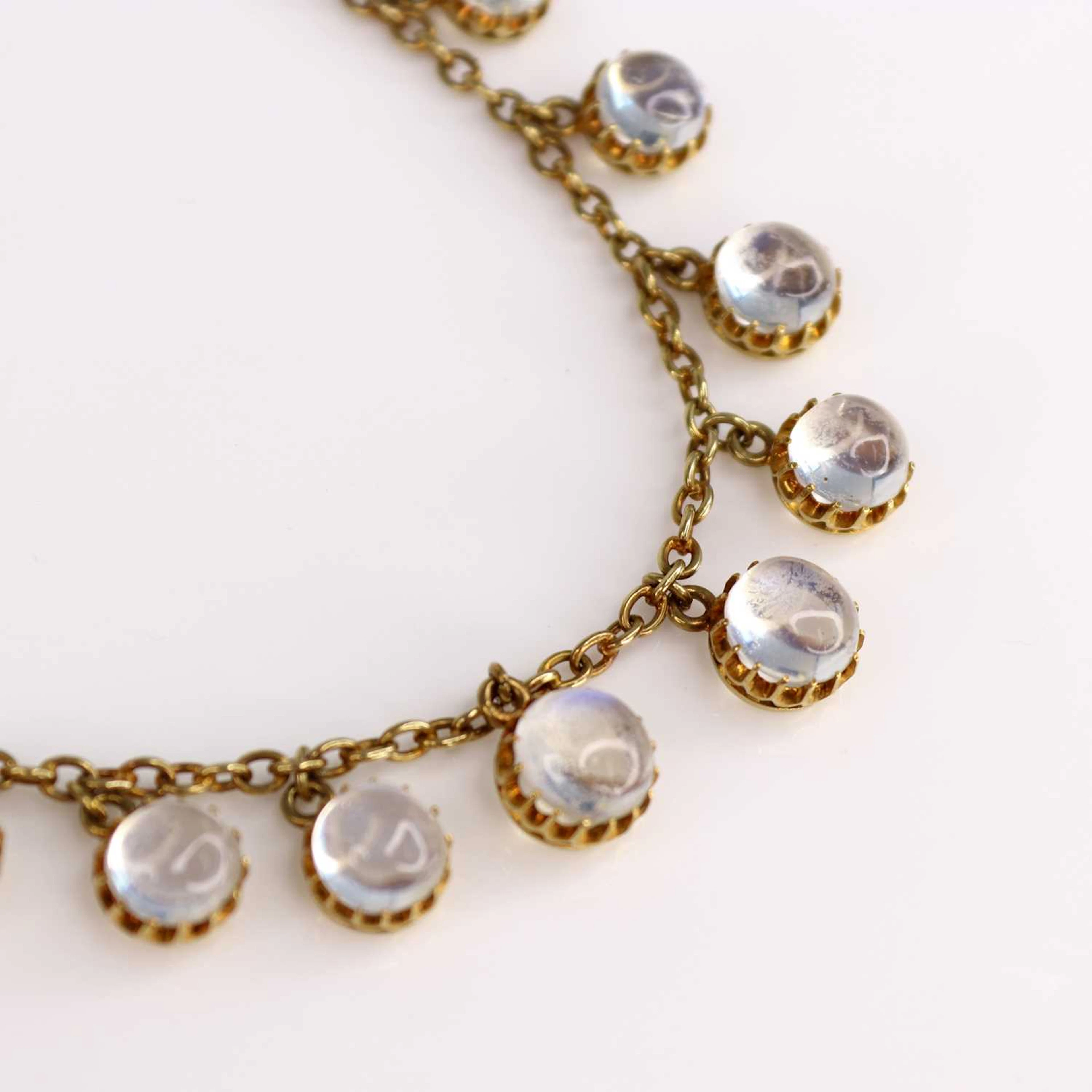 A yellow metal moonstone fringe necklace, featuring 25