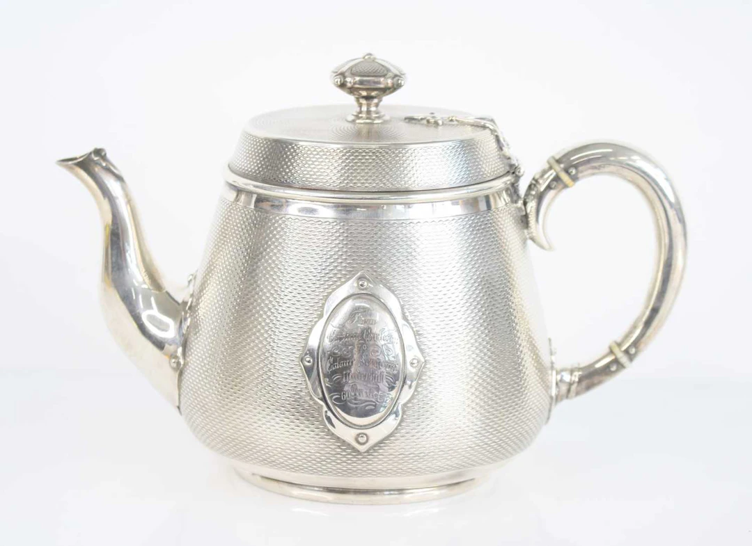 Lot 1040 - A Victorian silver plated teapot, having