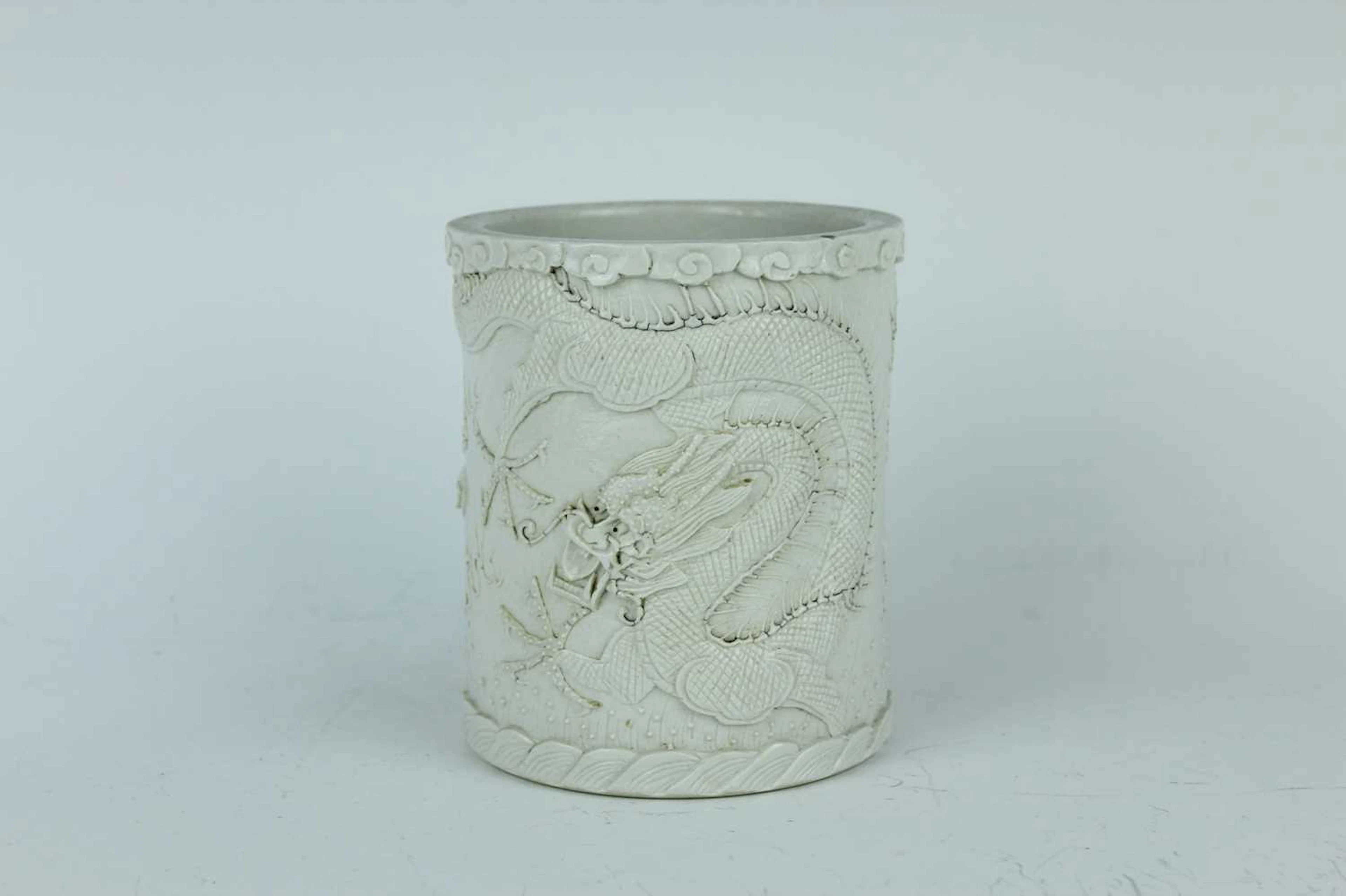 Lot 52 - A Chinese white-glazed carved dragon brush
