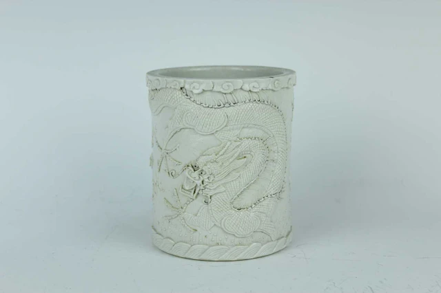 Lot 52 - A Chinese white-glazed carved dragon brush