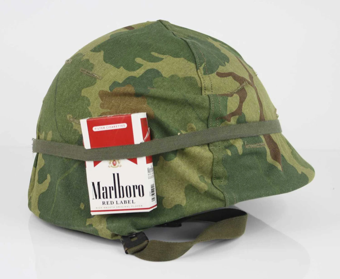 Lot 1134 - An American M1 steel helmet with camouflage
