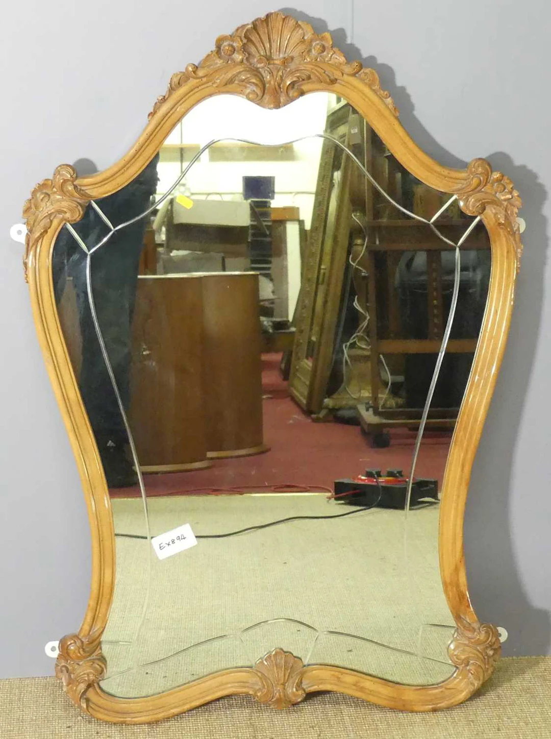 Lot 597 - A French walnut framed shaped wall mirror