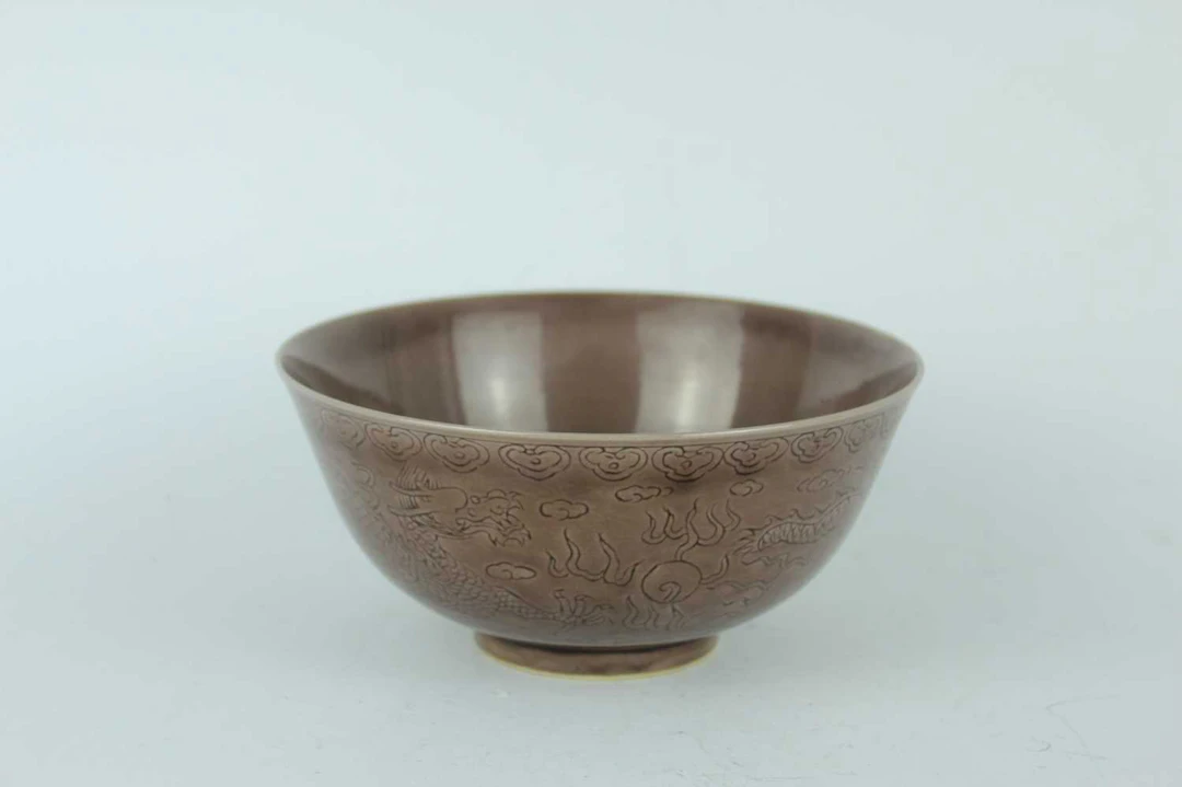 Lot 75 - A Chinese aubergine-glazed incised dragon