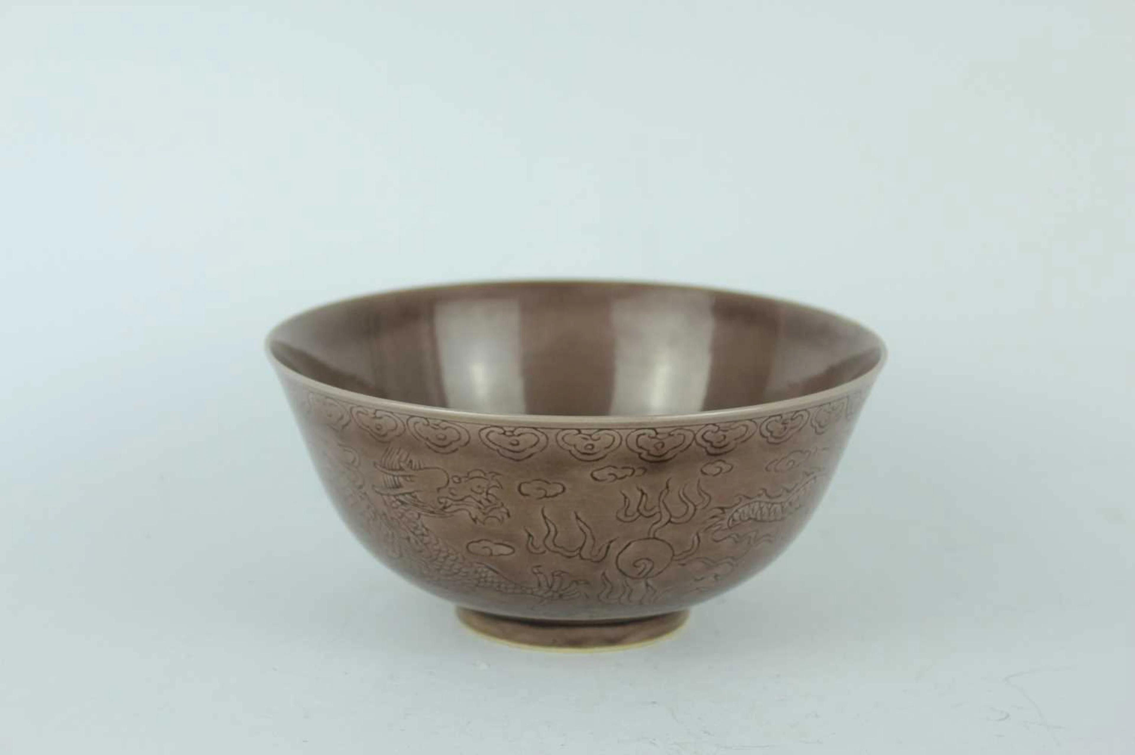 Lot 75 - A Chinese aubergine-glazed incised dragon