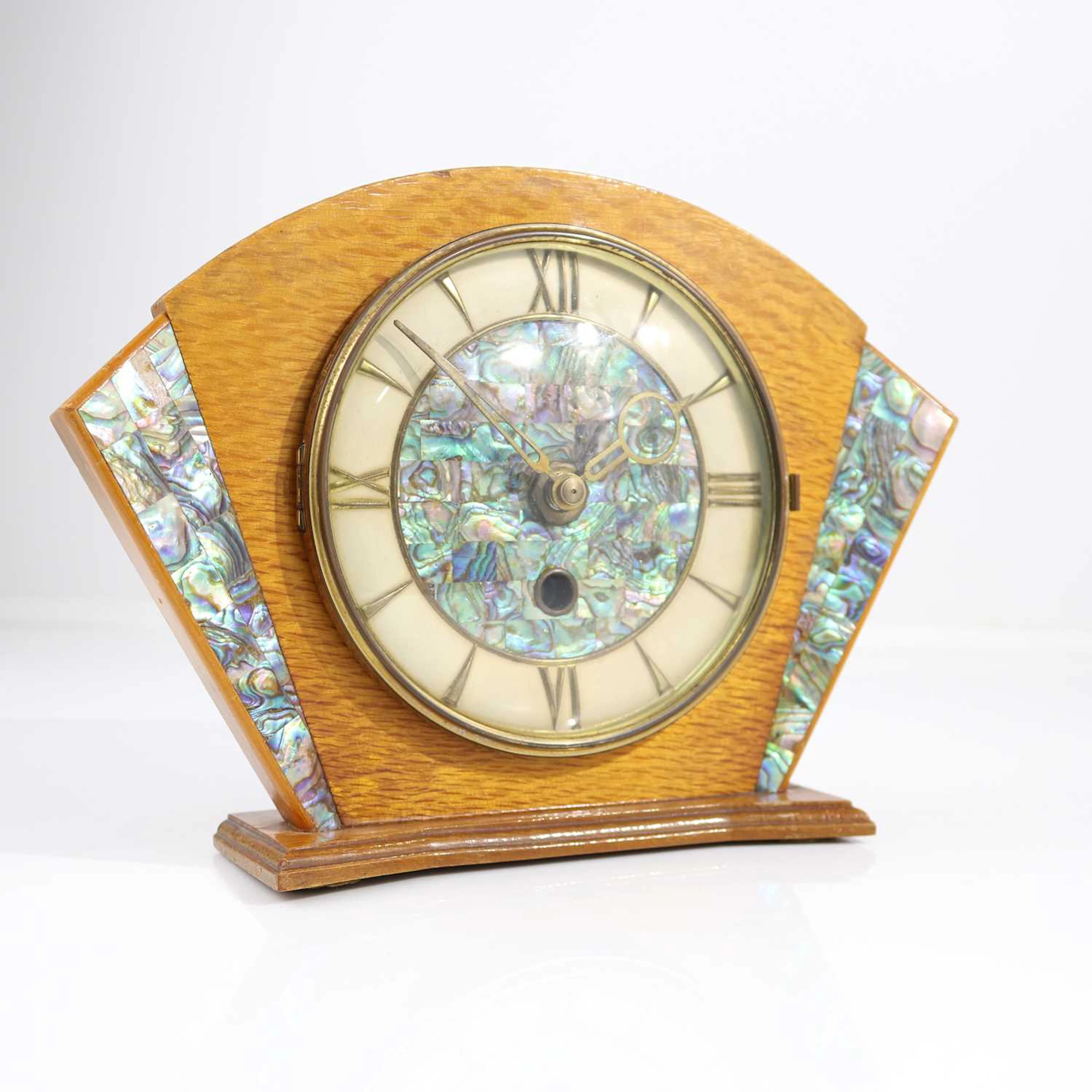 Lot 413 - An Art Deco oak mantel clock, decorated with