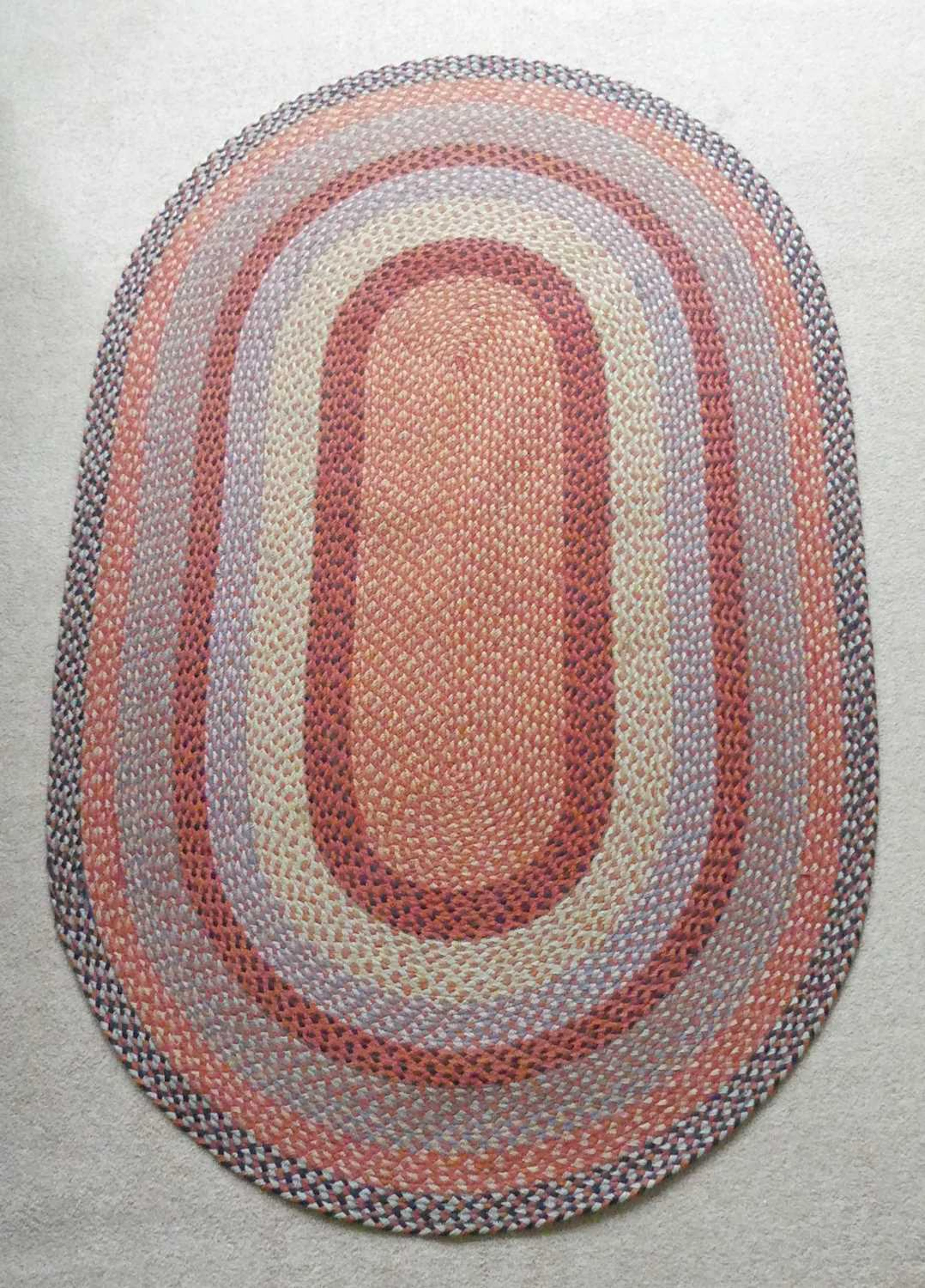 Lot 1255 - A contemporary braided oval rug, as