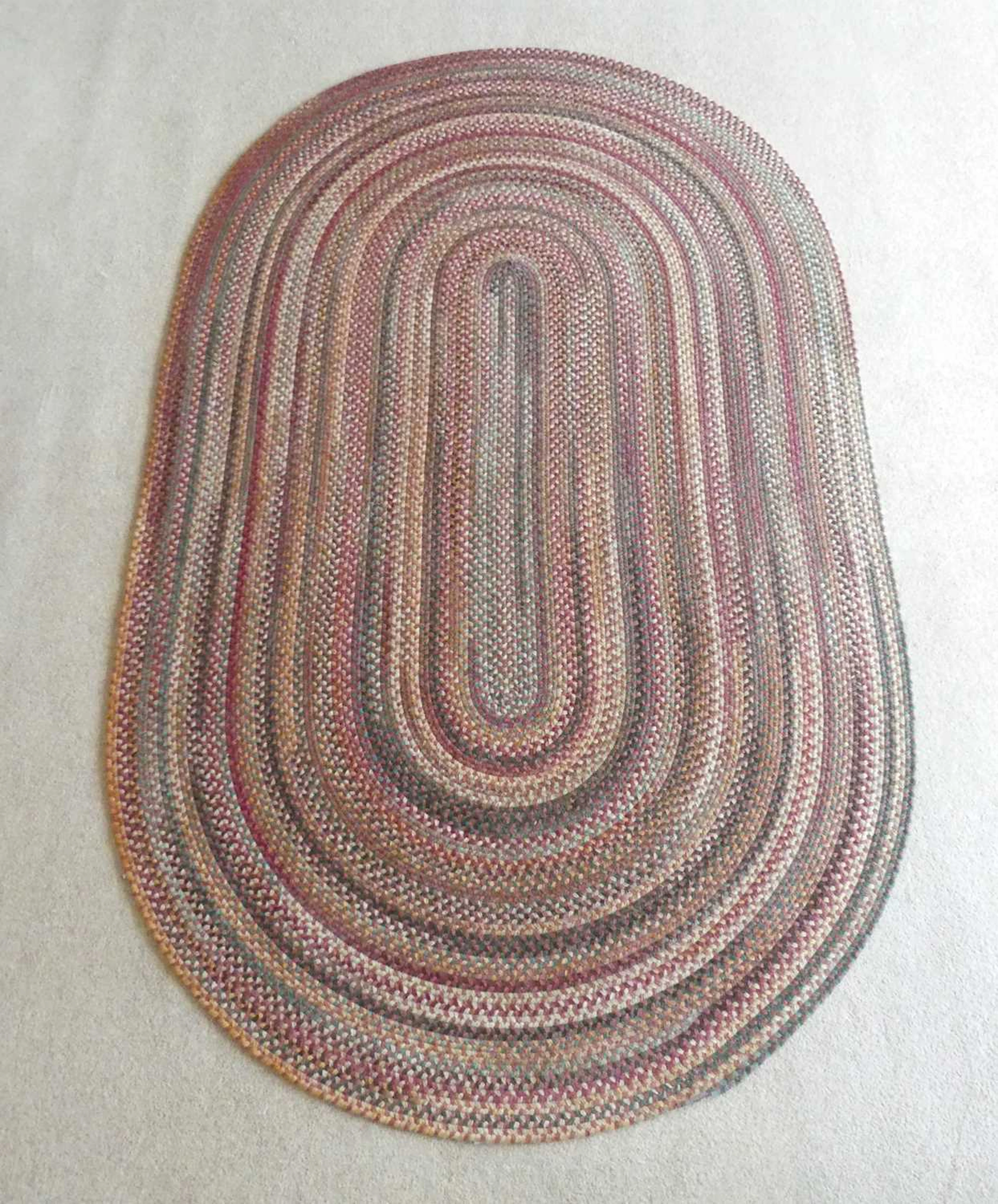 Lot 1257 - A contemporary braided oval rug, as