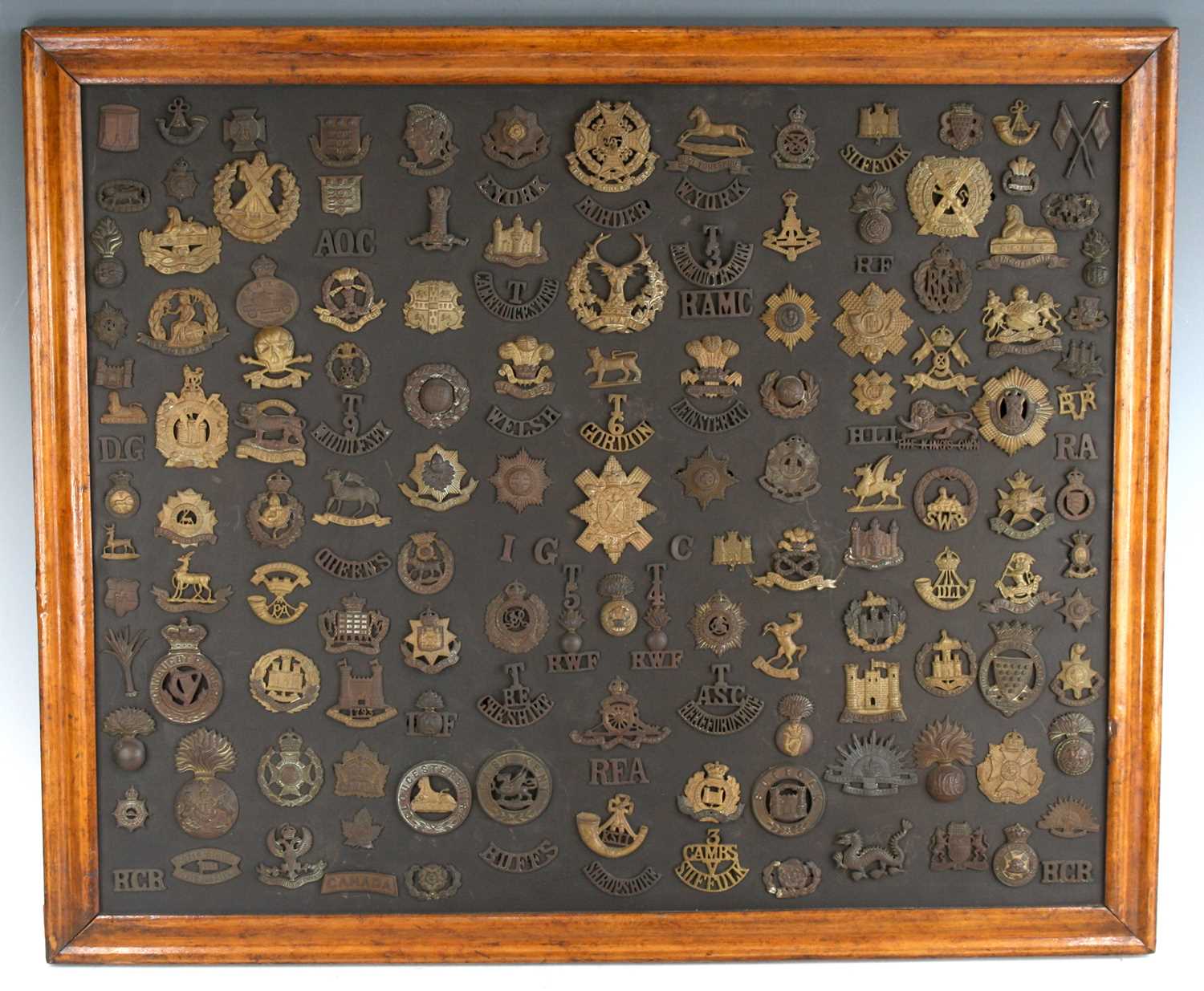 A large collection of early 20th century cap badges