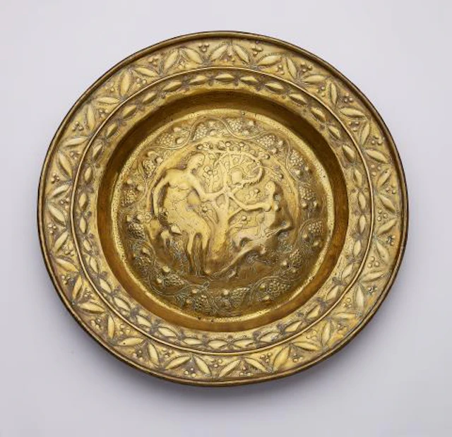 A brass alms bowl with Adam and Eve