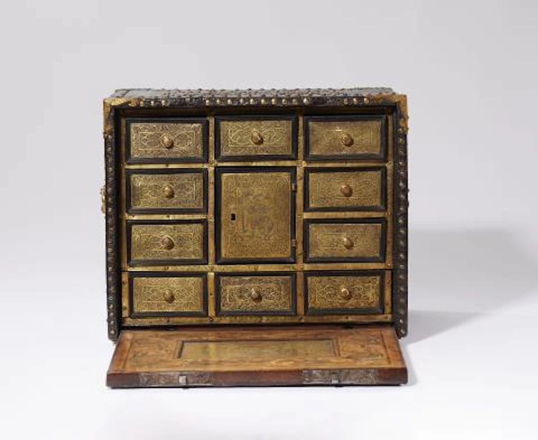 A cabinet with marquetry and riveted leather covering