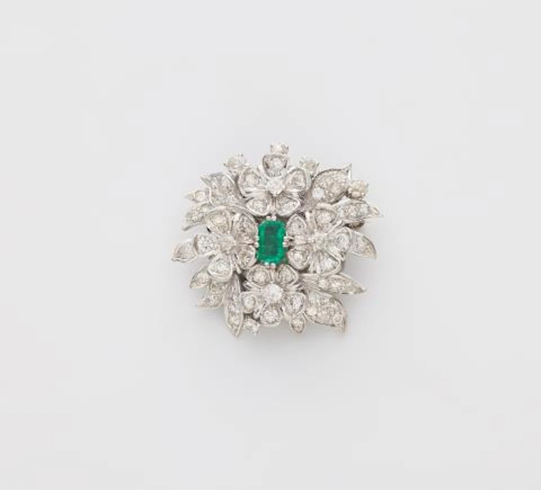 An 18k white gold diamond and emerald brooch made from a former clasp.