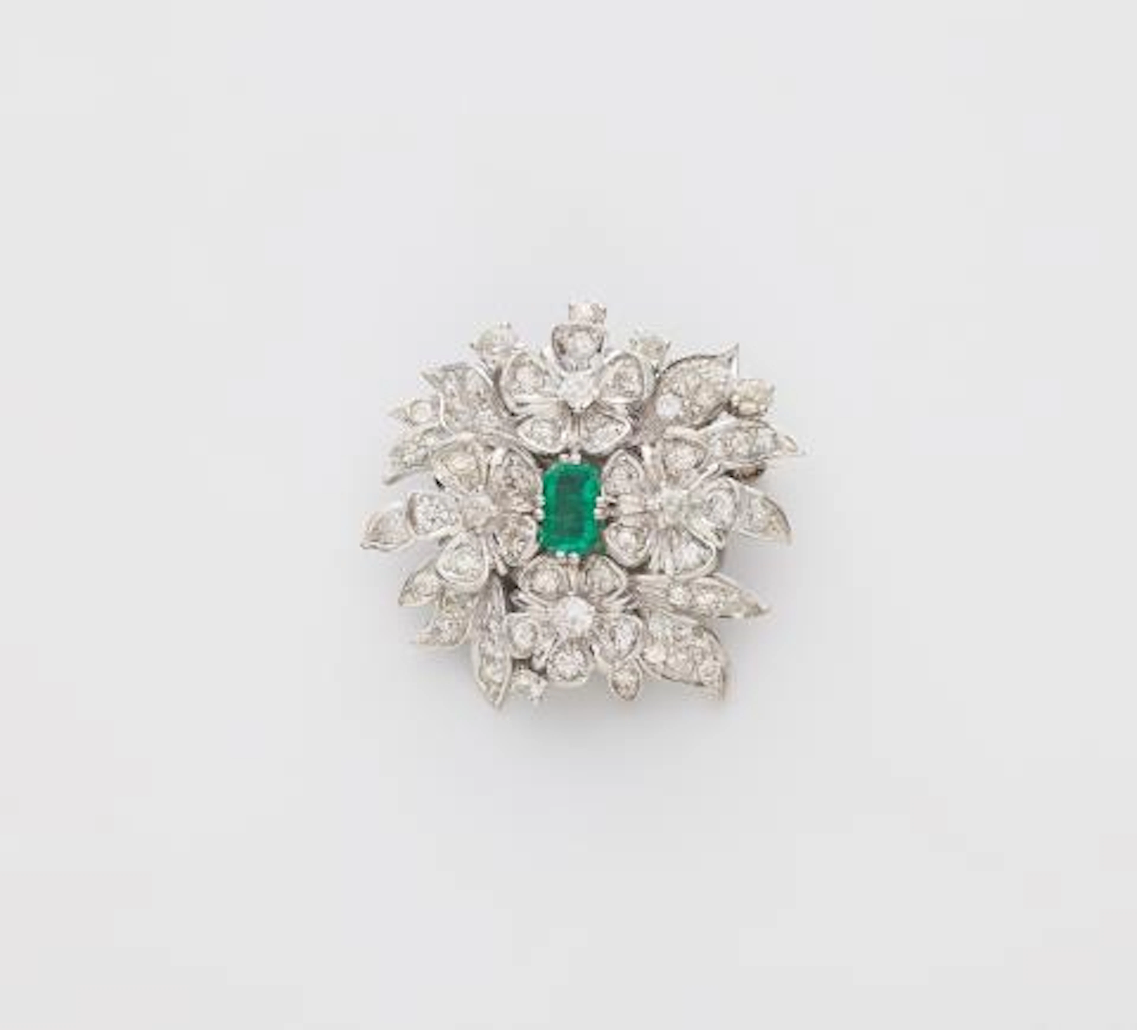 An 18k white gold diamond and emerald brooch made from a former clasp.
