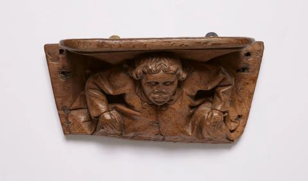 A carved oak miserichord with a figure