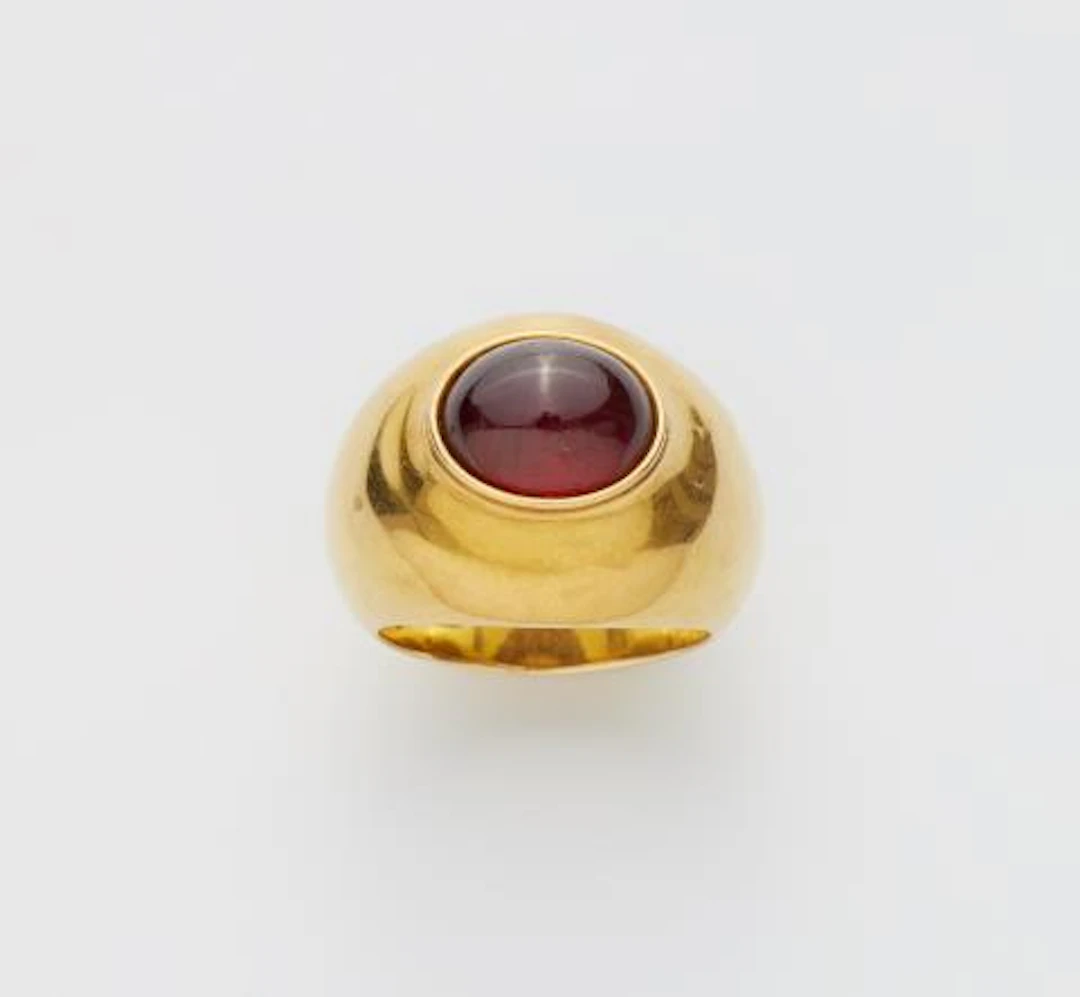 A German 18k gold and garnet cabochon ring with a romantic inscription