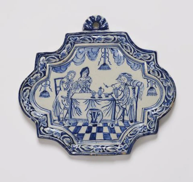 A small Dutch Delft faience plaque with a genre scene