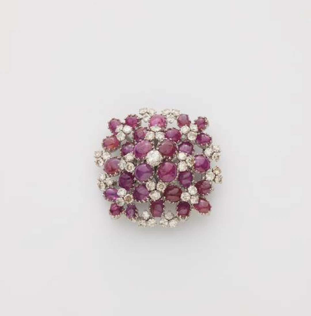 An 18k white gold diamond and ruby cabochon cocktail brooch.
