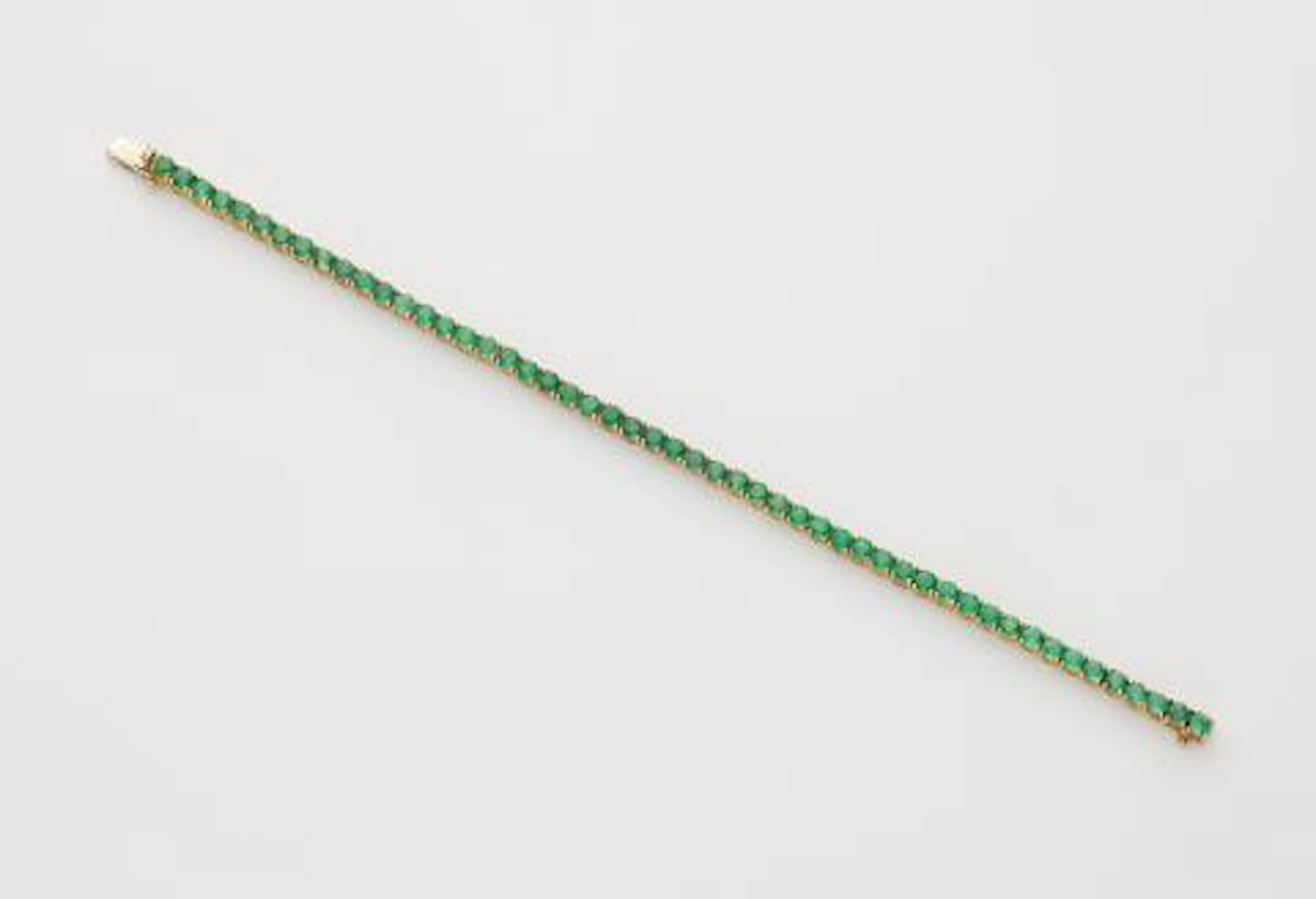 An 18k white gold and emerald rivière bracelet.
