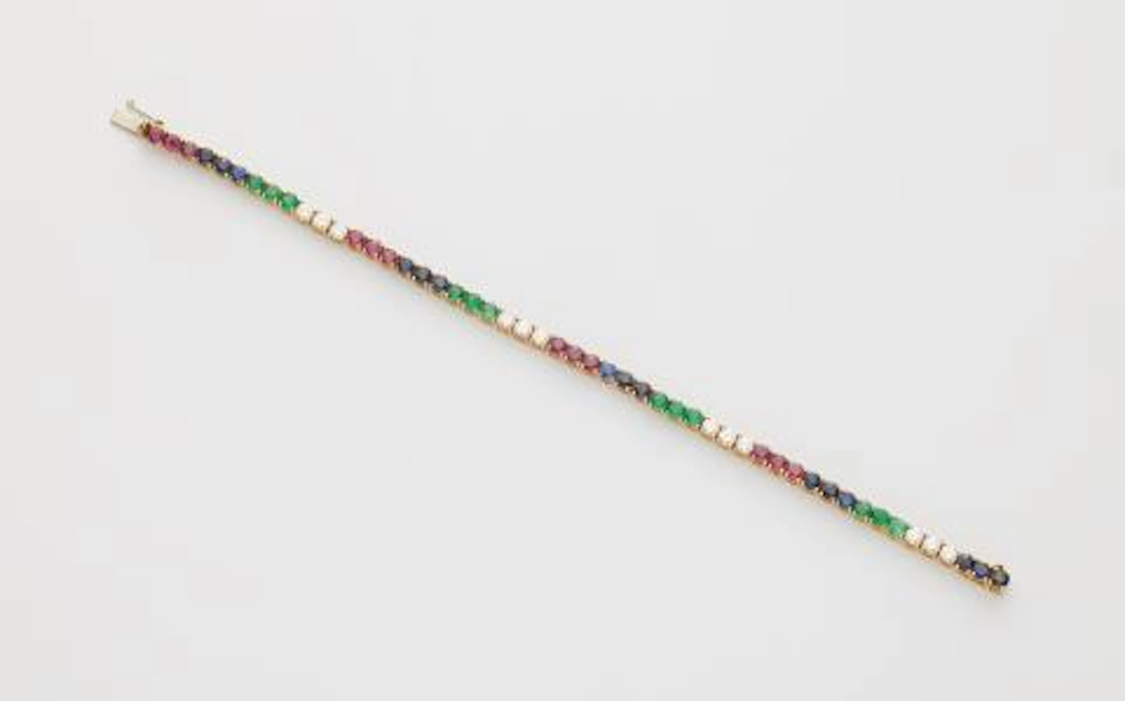 An Italian 18k white gold ruby sapphire emerald and diamond rivière bracelet.