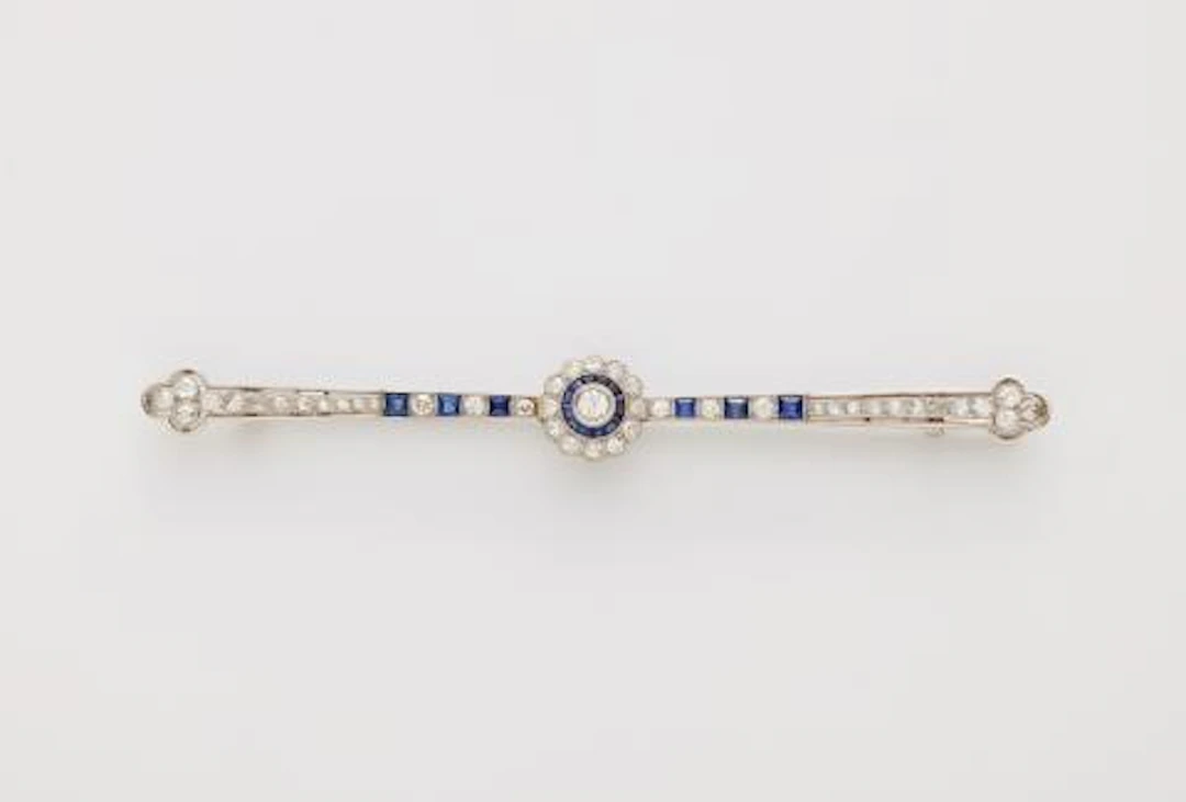 A French platinum diamond and calibré sapphire Art Déco bar brooch.