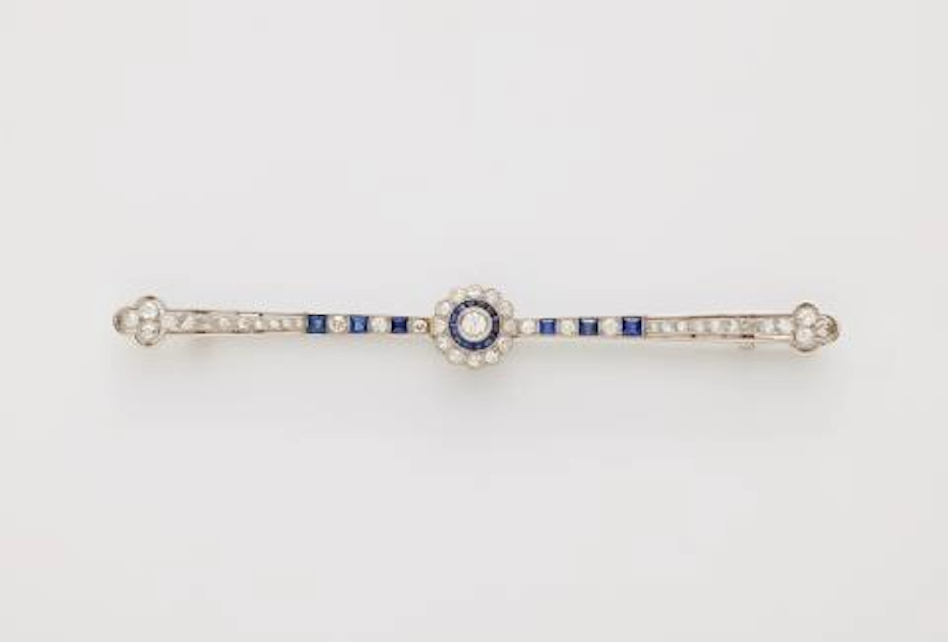 A French platinum diamond and calibré sapphire Art Déco bar brooch.