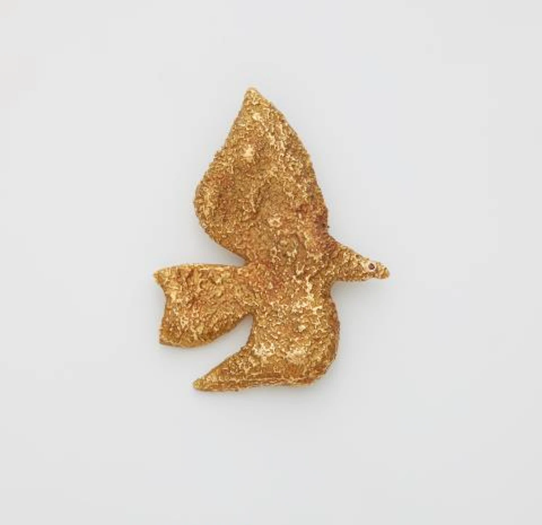 A textured 18k gold brooch "Thyria" with ruby collet eye.