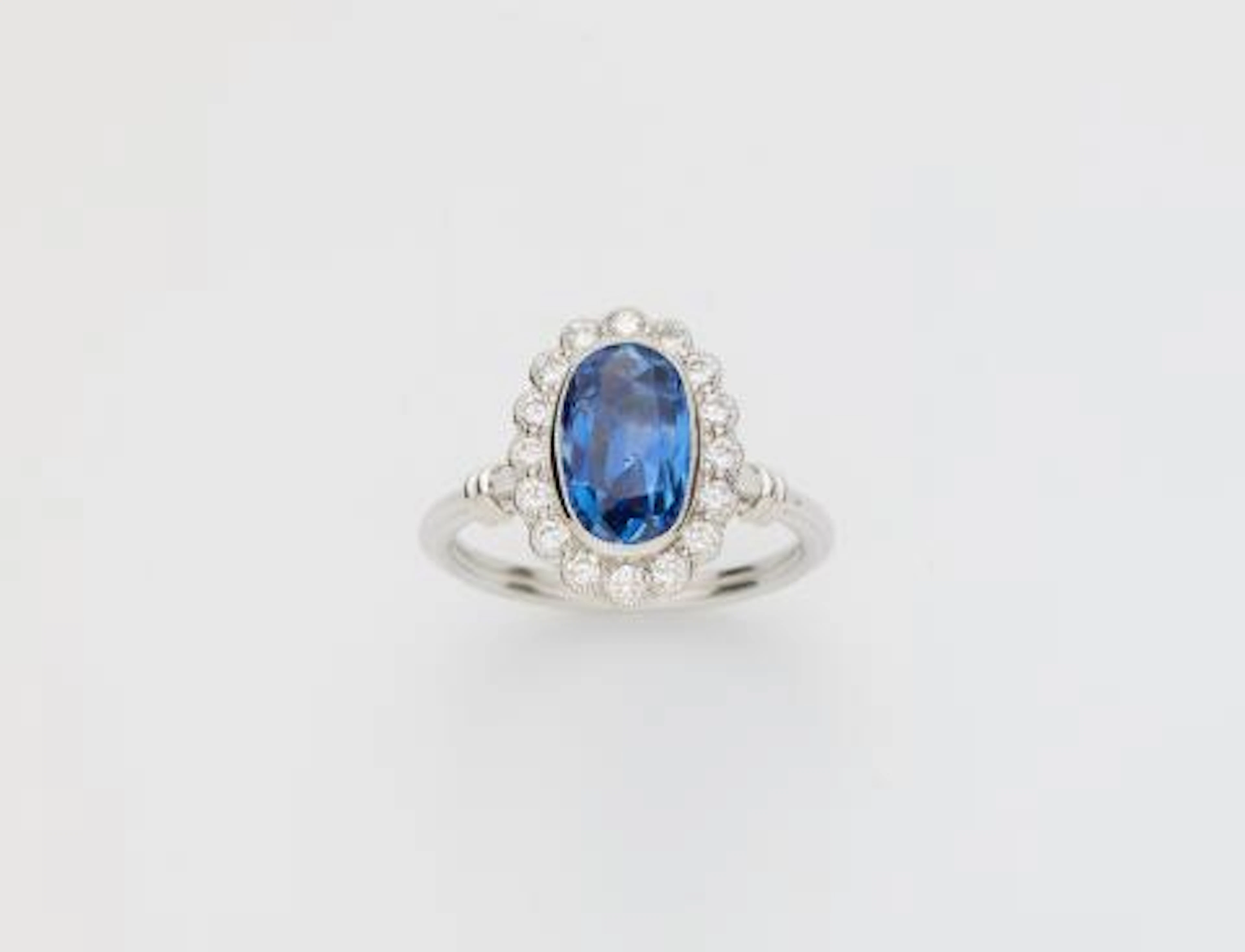 A 14k white gold diamond and natural Ceylon sapphire (NTE) cluster ring.