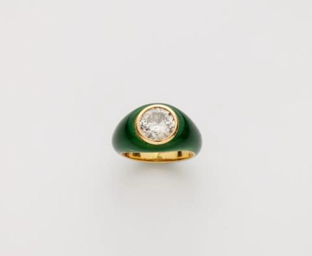 An 18k gold translucent green enamel and diamond solitaire band ring.