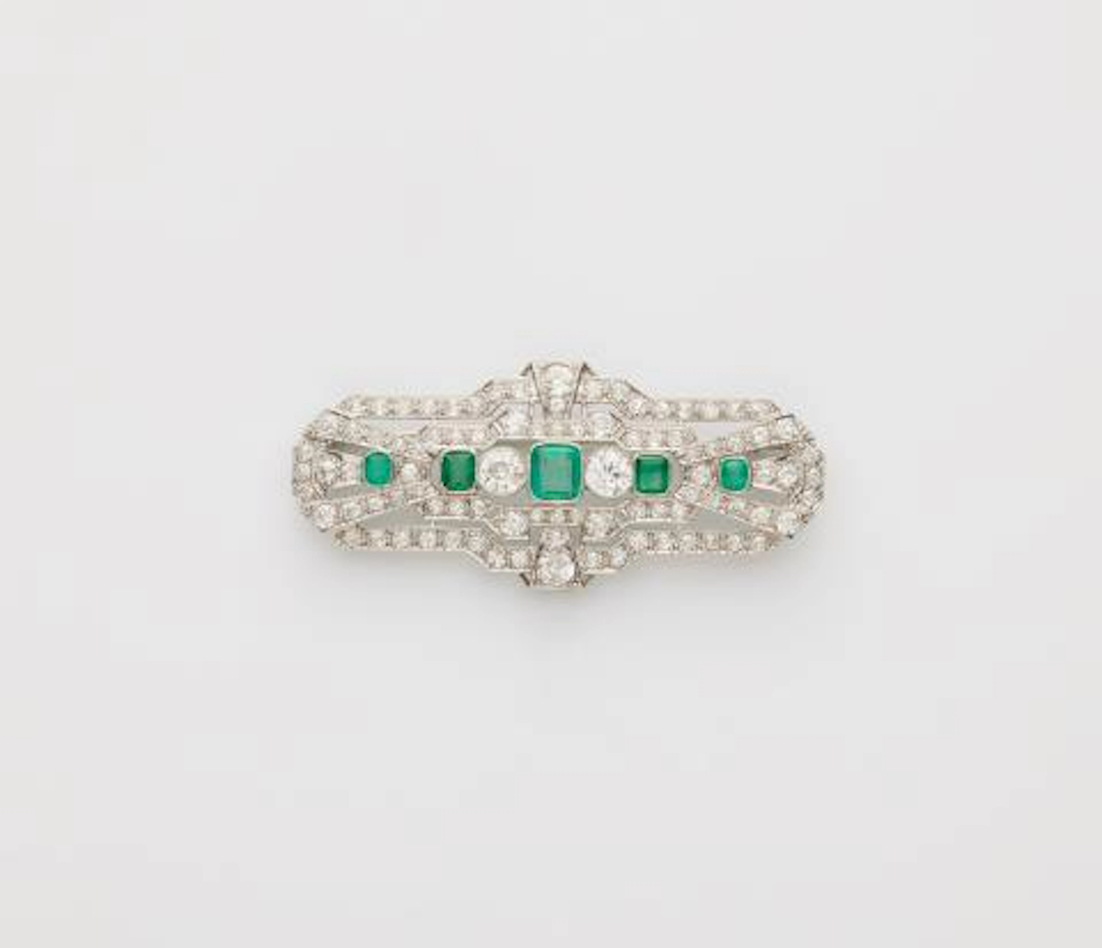 A 14k white gold diamond and emerald Art Déco brooch.