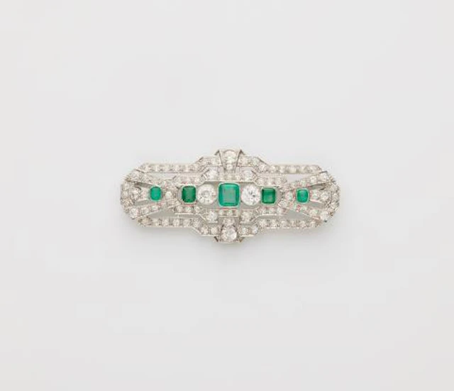 A 14k white gold diamond and emerald Art Déco brooch.