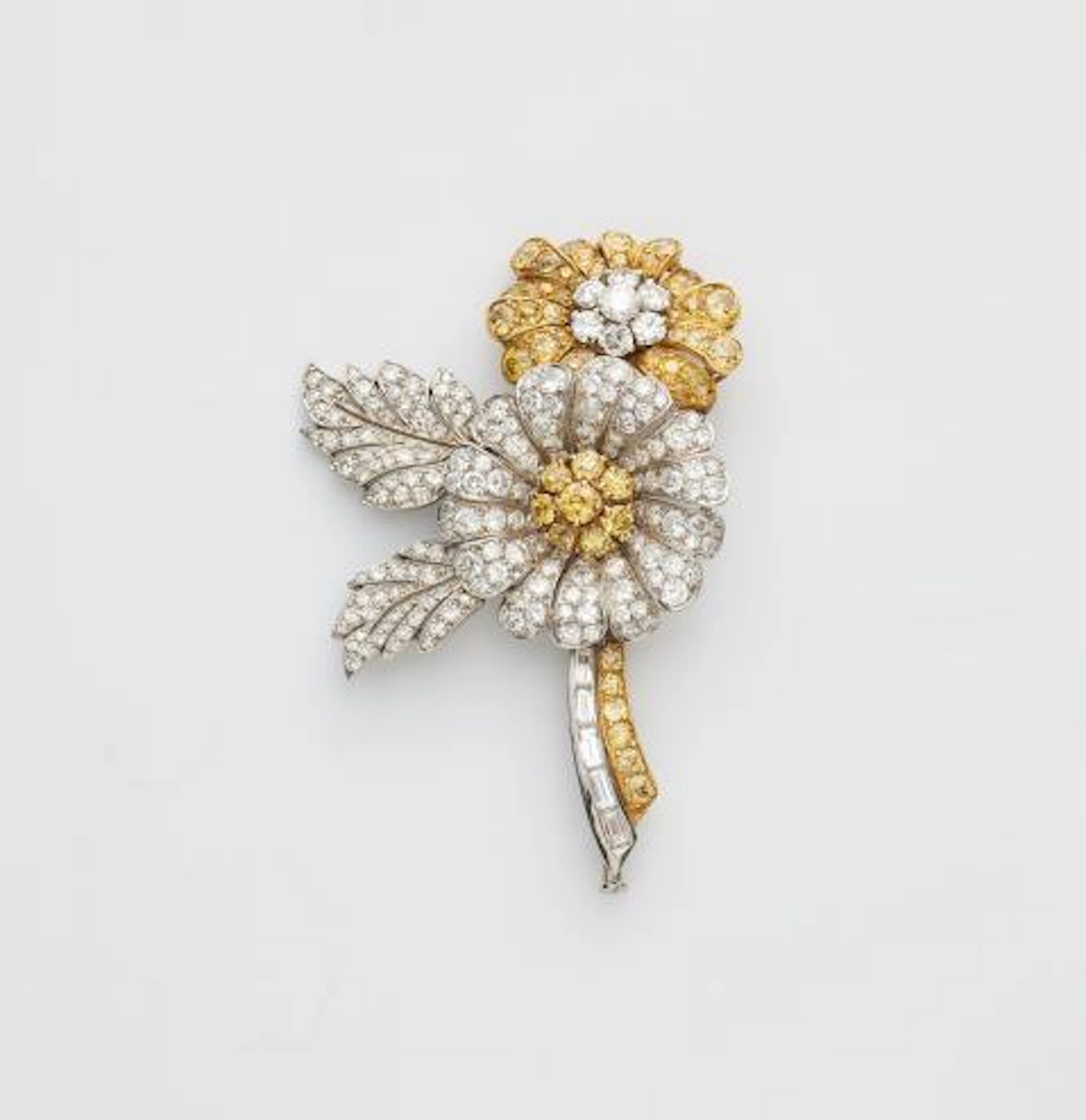 A platinum 18kt yellow gold white and yellow diamond flower brooch.