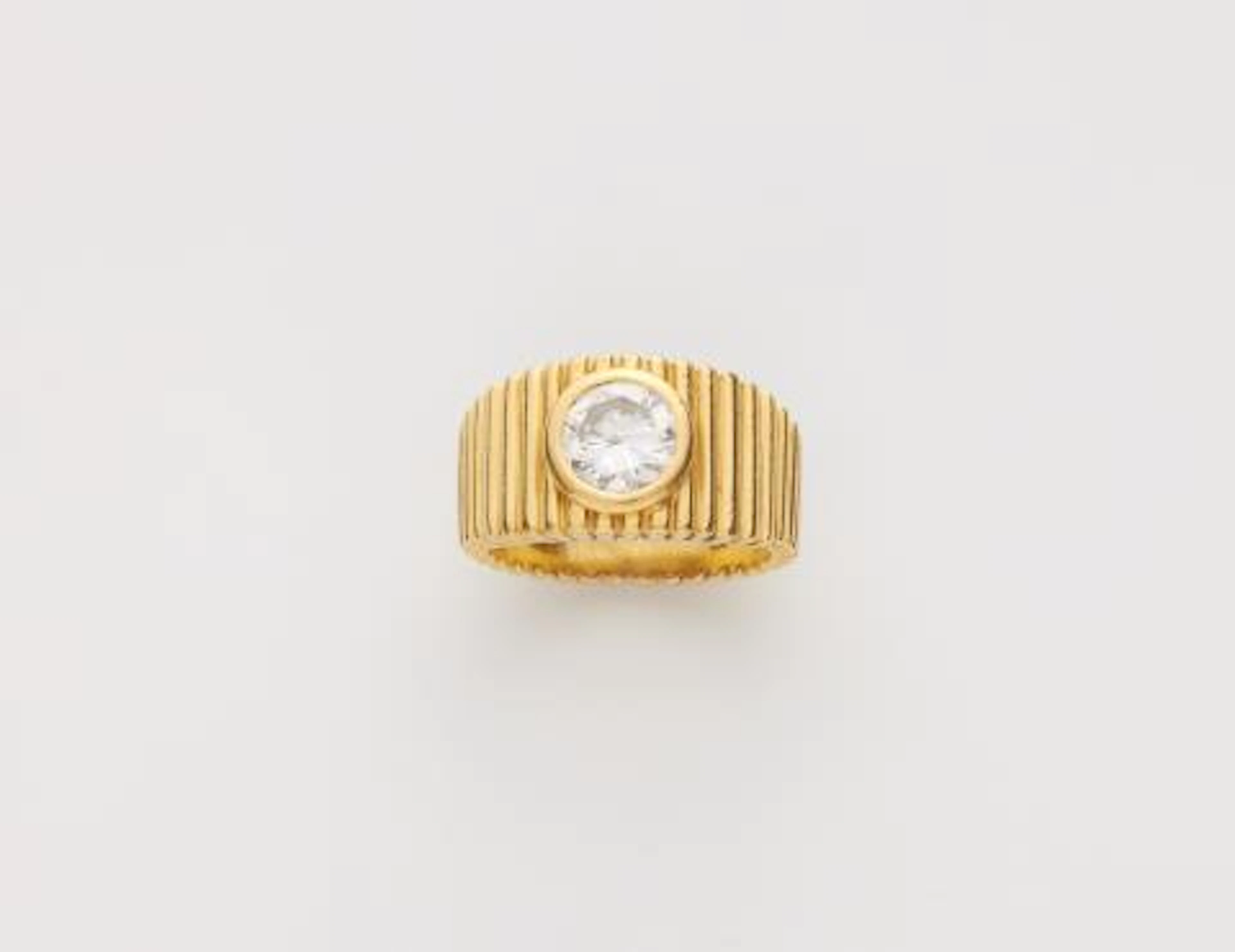 An 18k yellow gold and brilliant-cut diamond solitaire band ring.