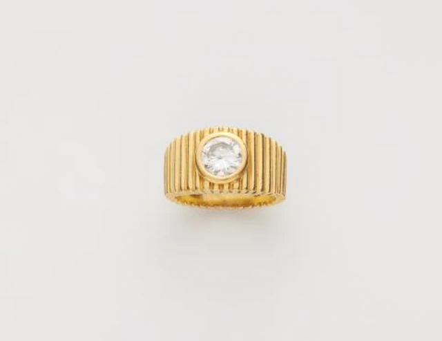 An 18k yellow gold and brilliant-cut diamond solitaire band ring.