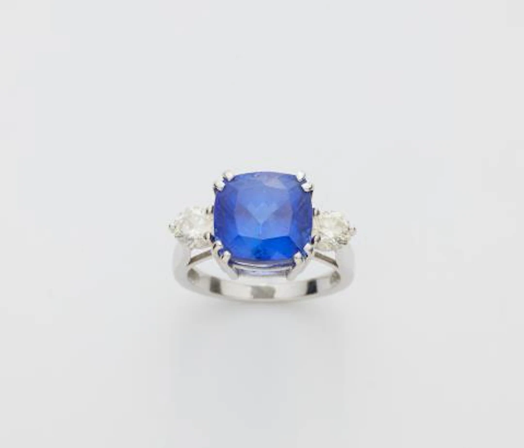 An 18k white gold diamond and cushion-cut tanzanite three stone ring.