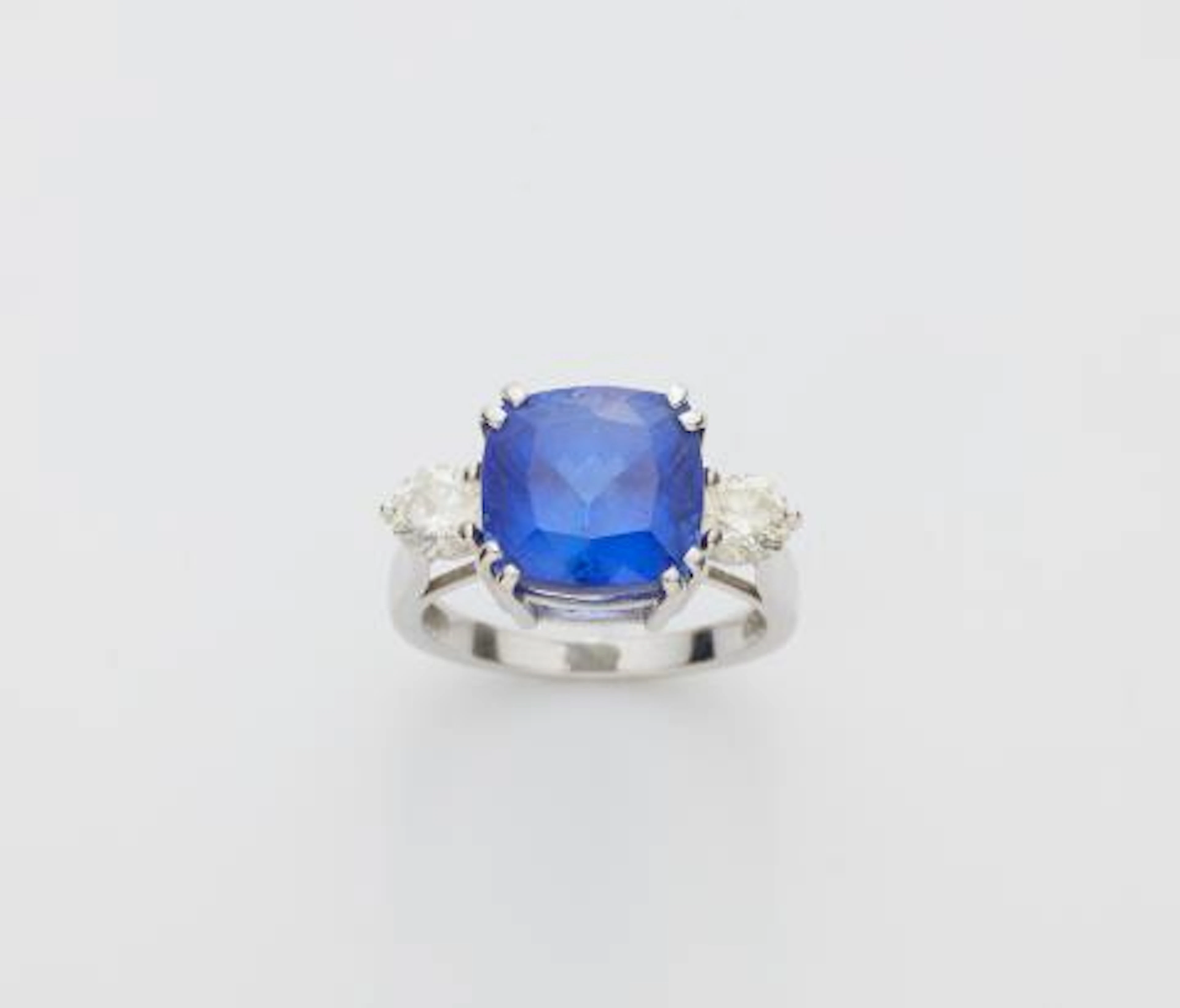 An 18k white gold diamond and cushion-cut tanzanite three stone ring.