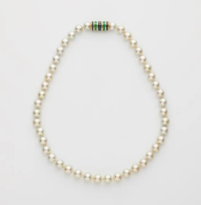 A fine cultured pearl necklace with an 18k yellow gold emerald and