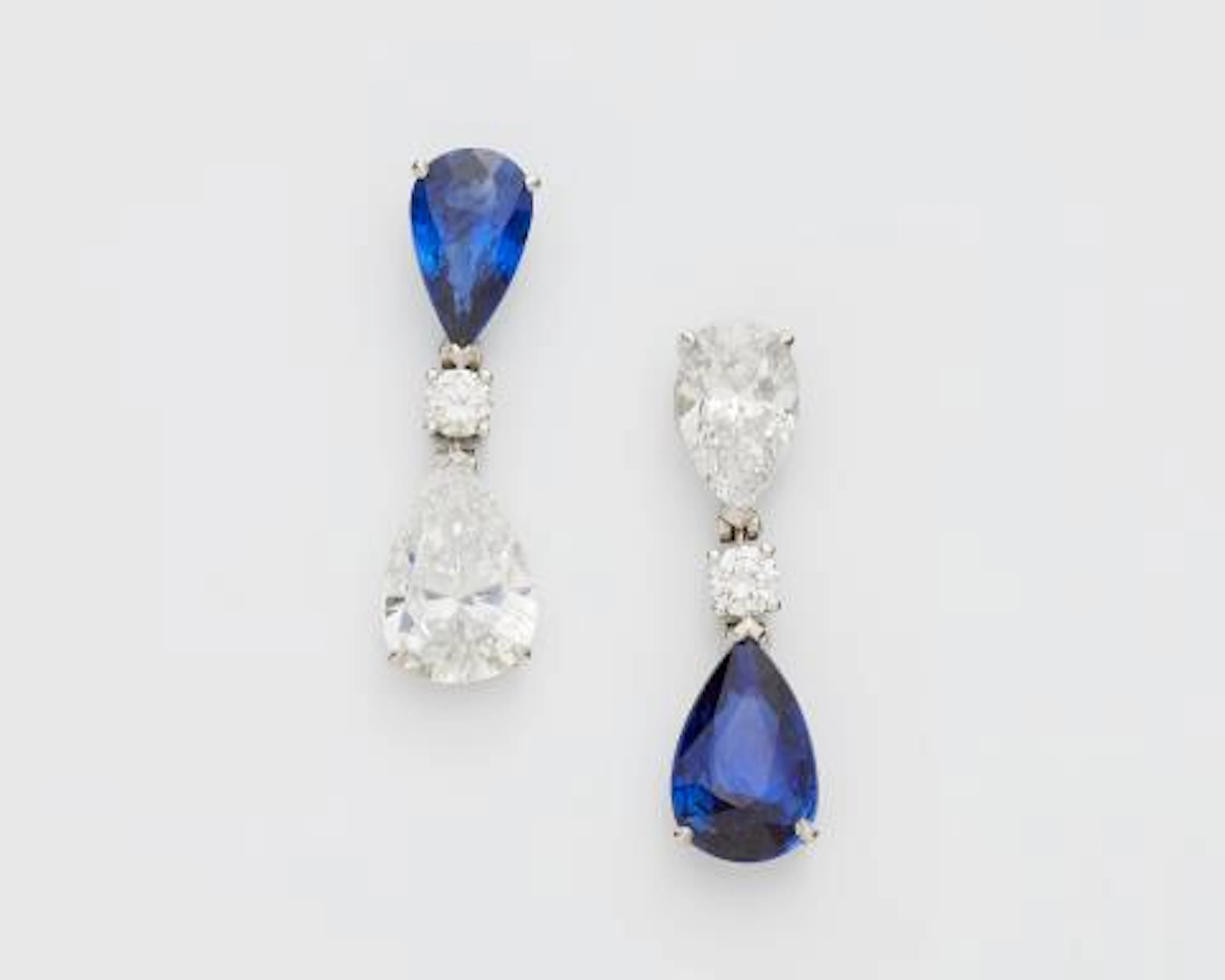 A pair of 18k white gold and pear-cut diamond and sapphire droplet earrings.