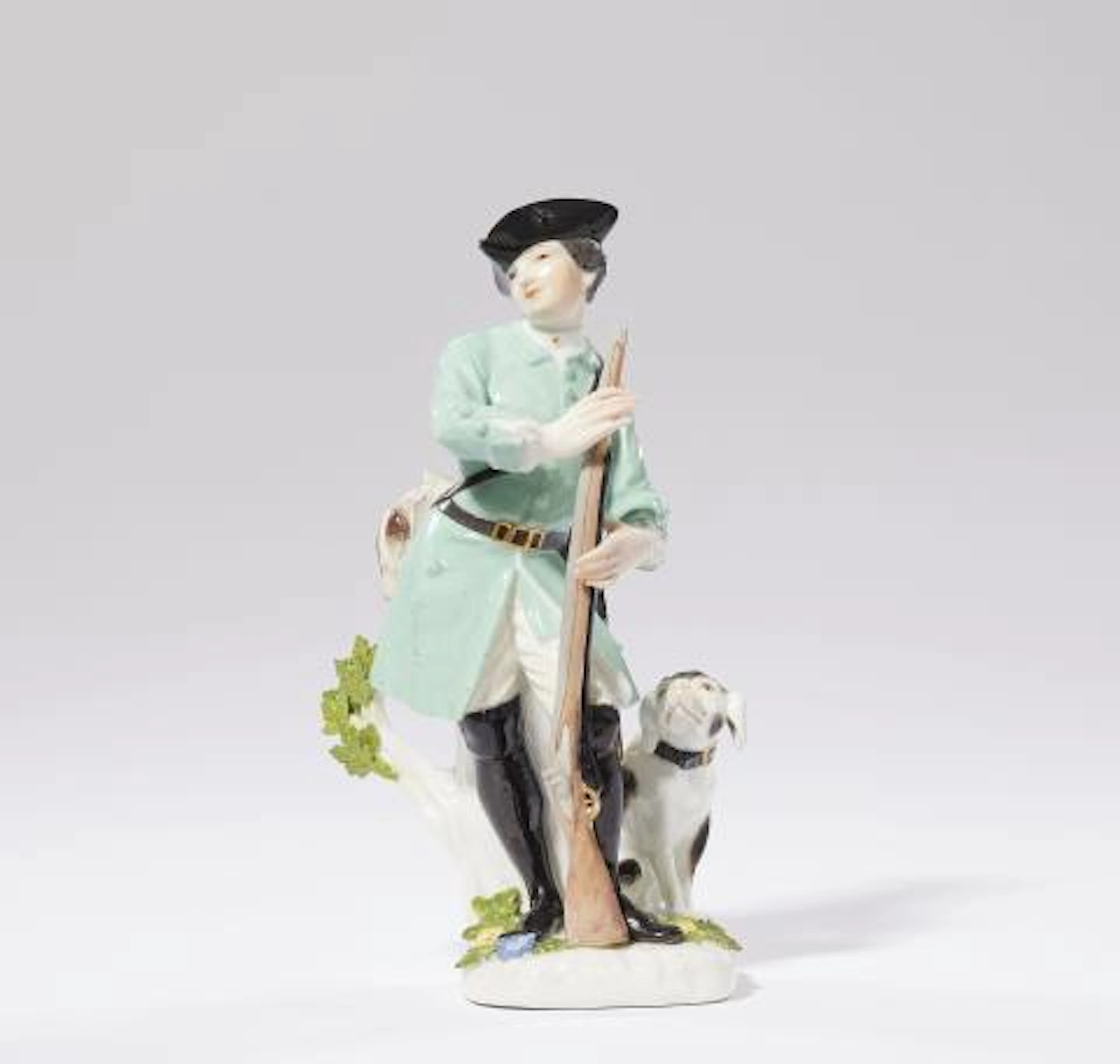 A Meissen porcelain figure of a hunter with a gun and dog