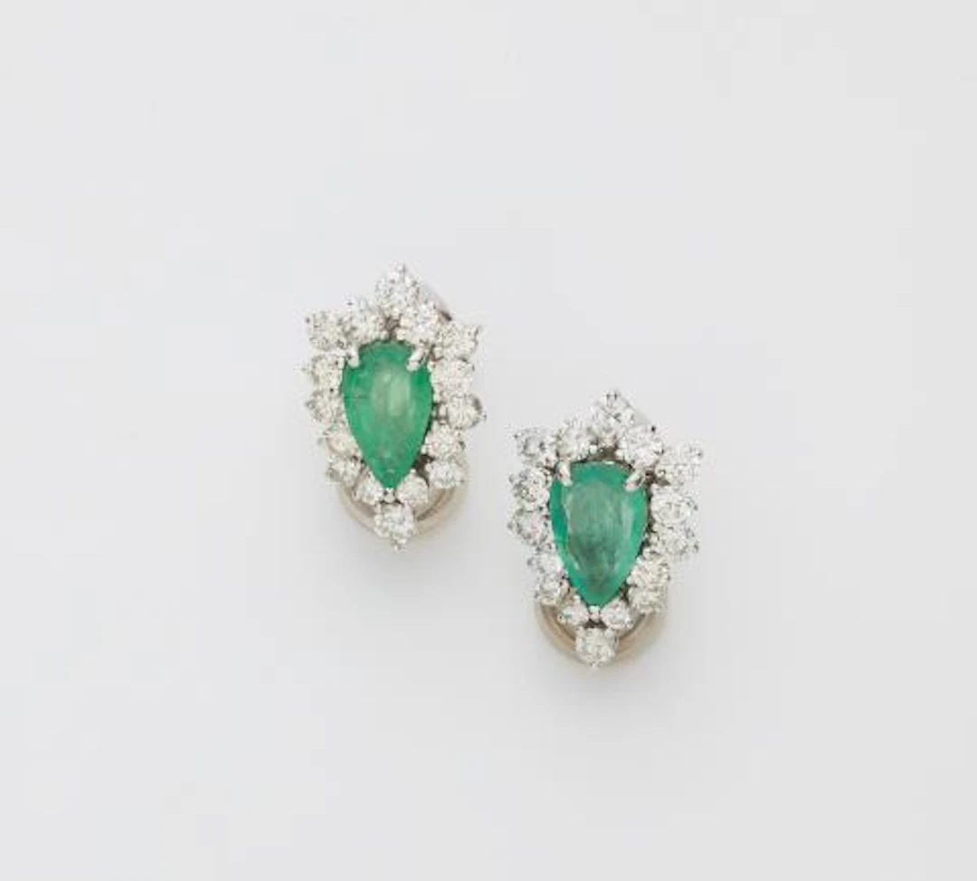 A pair of 18k white gold diamond and pear-cut emerald clip earrings.