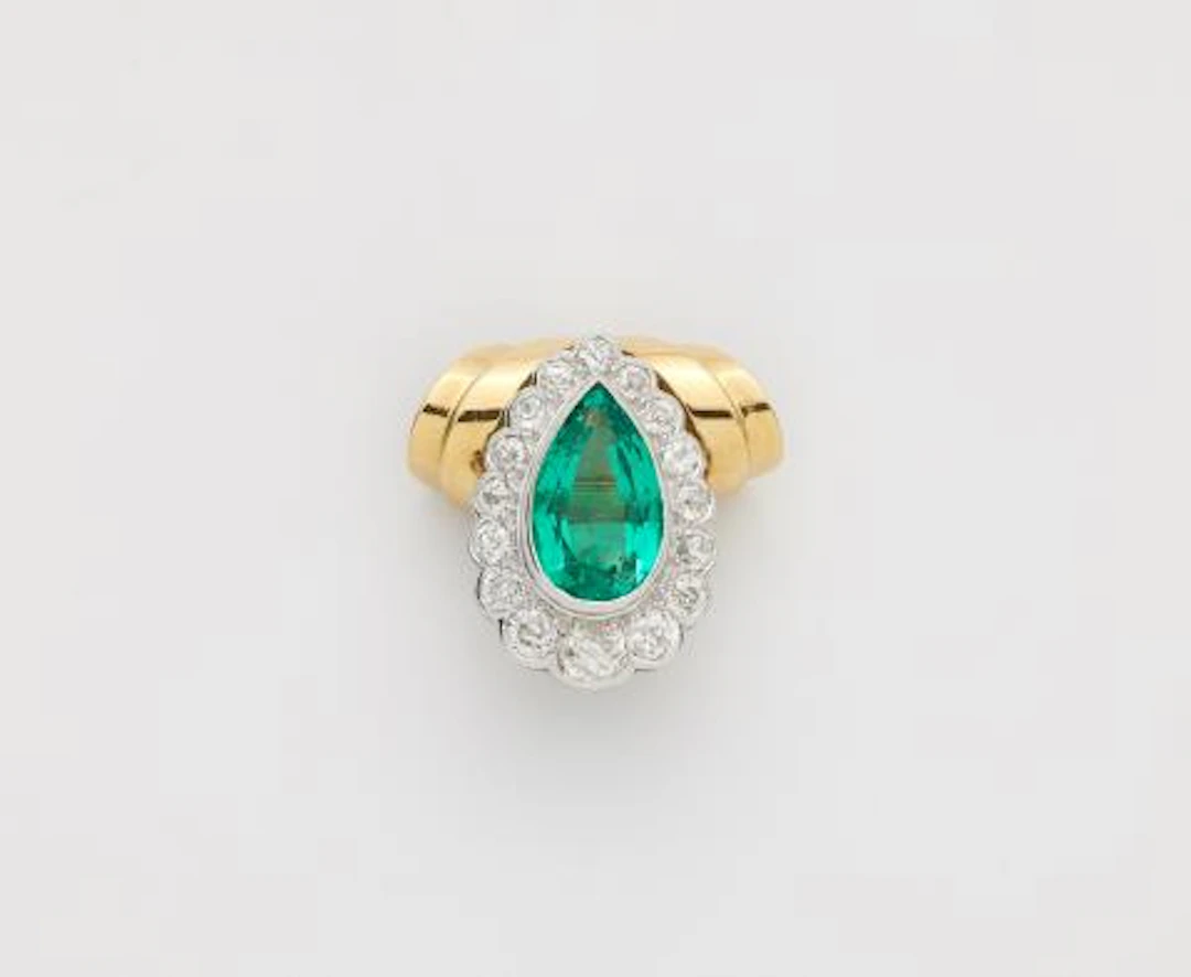 An 18k gold pendant using a platinum diamond and Colombian emerald