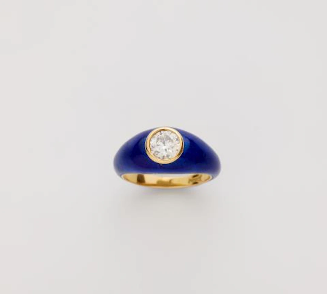 An 18k gold translucent blue enamel and diamond solitaire band ring.