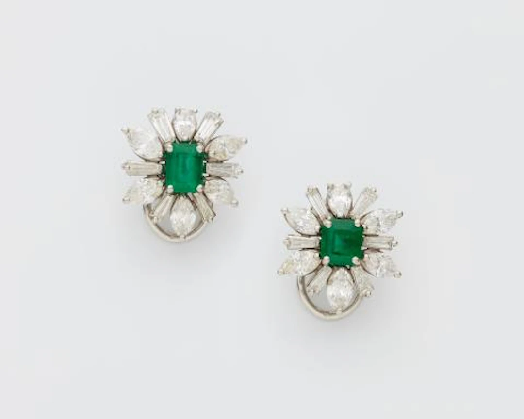 A pair of 14k white gold emerald and diamond flower clip earrings.
