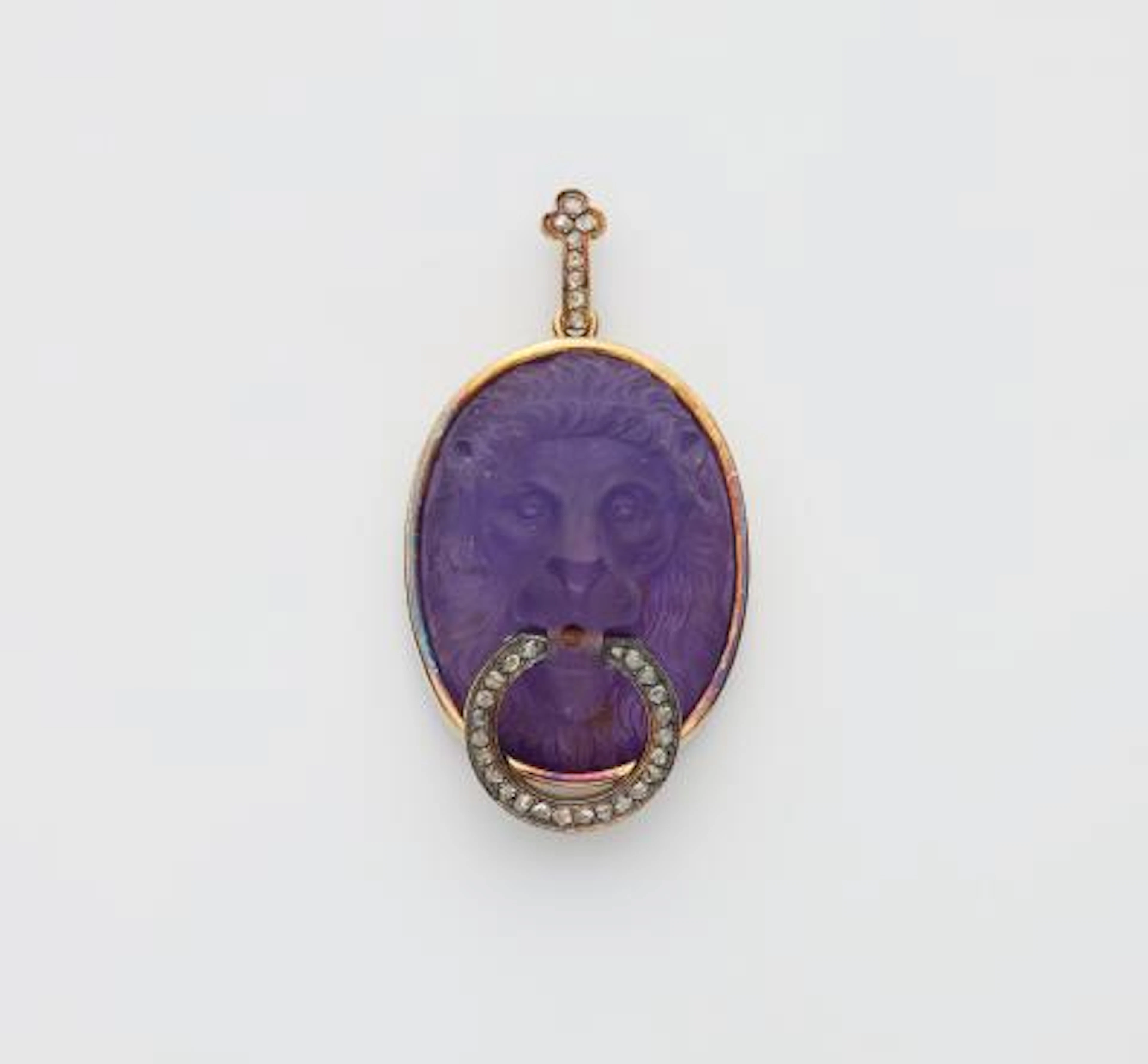 A 14k gold diamond and amethyst cameo pendant depicting a lion head