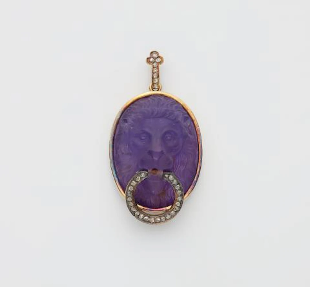 A 14k gold diamond and amethyst cameo pendant depicting a lion head