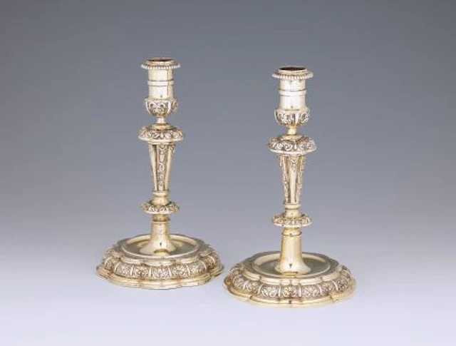 An ornate pair of Regencé silver-gilt candlesticks