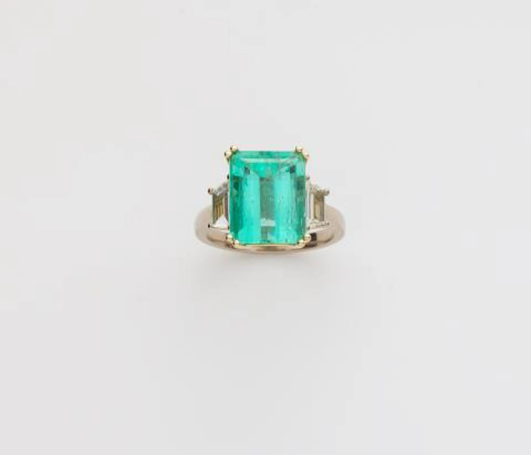 An 18k gold diamond and Colombian emerald three stone ring