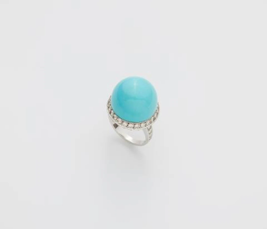 An 18k white gold diamond and turquoise sphere ring.
