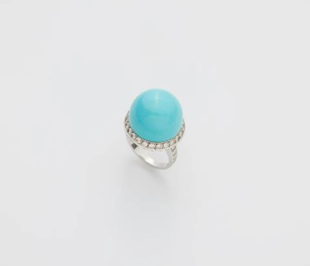 An 18k white gold diamond and turquoise sphere ring.