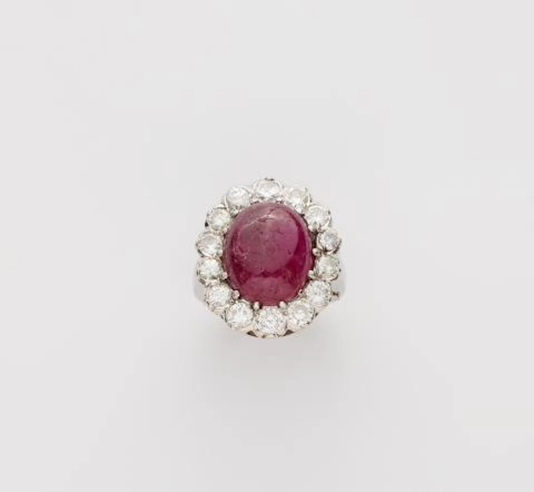 A 14k white gold diamond and ruby cabochon cluster ring.