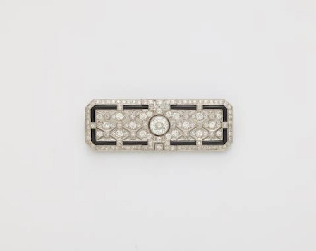 A platinum 18k gold diamond and onyx Art Déco brooch with original